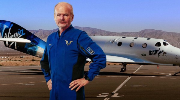 Главный пилот Virgin Galactic Дэйв Маккей показывает свой костюм перед космическим самолетом VSS Unity