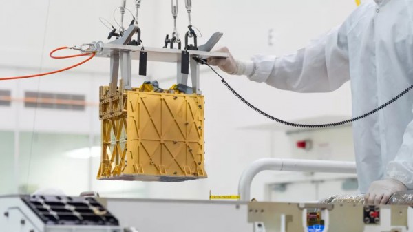 Техники осторожно опускают прибор Mars Oxygen In-situ Resource Utilization Experiment (MOXIE) в брюшко марсохода Perseverance