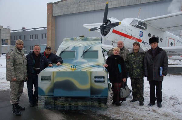 Новый броневик в окружении создателей на фоне легендарного АН-2
