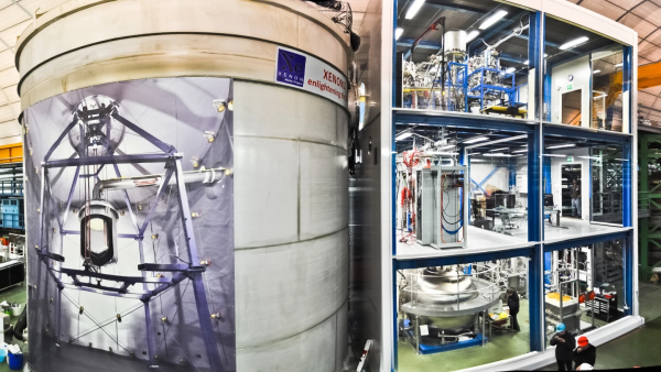 Помещение XENON1T, слева - резервуар для воды, содержащий сам инструмент, с плакатом, показывающим, что внутри, справа - трехэтажное служебное здание