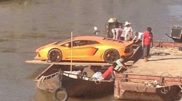 Оранжевый Lamborghini Aventador грузят на лодку