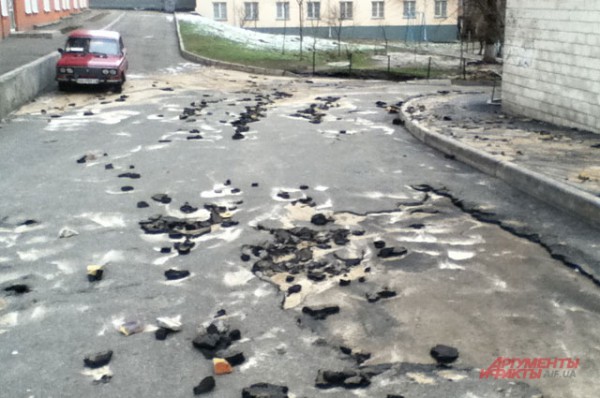 В 100 метрах от ямы валяются глыбы асфальта и камни