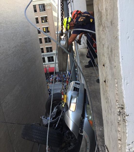 Свалившийся с 9 этажа парковки автомобиль зацепился за провода