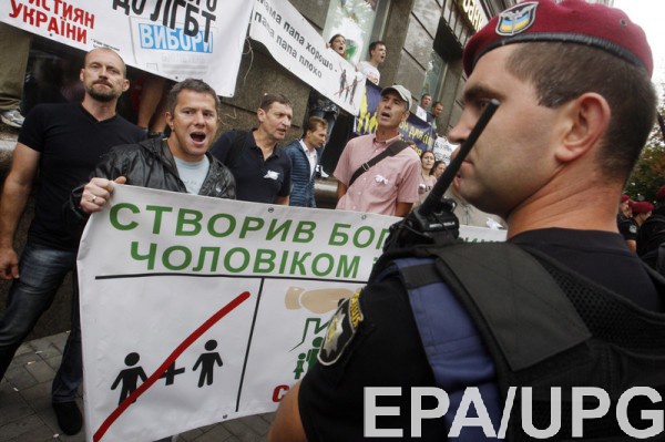Полицейский на фоне протестующих против пропаганды ЛГБТ